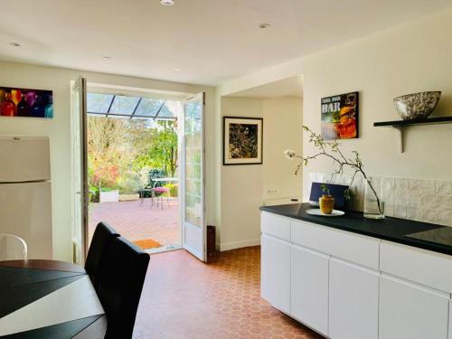 Il comprend une cuisine avec un comptoir et une porte donnant sur une terrasse. dans l'établissement Maison Briarde, à Montgé