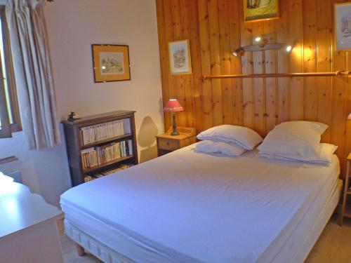 - une chambre avec un grand lit blanc et des murs en bois dans l'établissement T3 calme avec balcon, parking et cave à 500m du centre - FR-1-629-57, à Samoëns