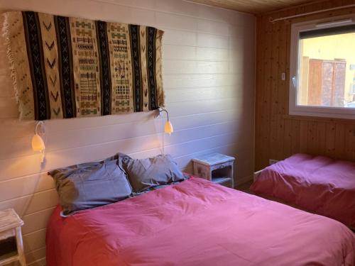 a bedroom with a bed with purple sheets and a window at Chalet Le Monêtier-les-Bains, 3 pièces, 6 personnes - FR-1-762-25 in Le Monêtier-les-Bains