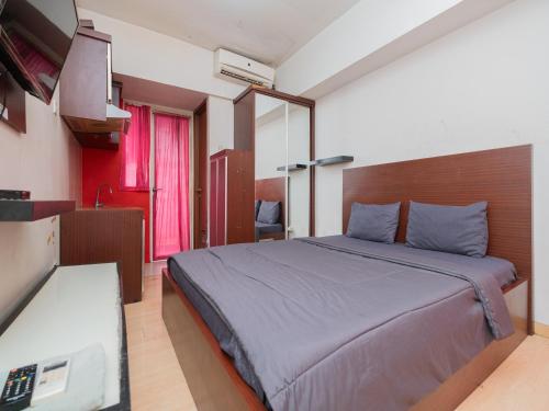 una camera con un grande letto e una televisione di Apartemen Green Lake View Ciputat by Alfa Rooms a Pondokcabe Hilir