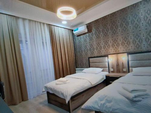 Cette chambre comprend 2 lits et une fenêtre. dans l'établissement usjwjeeu, à Yakkasaray