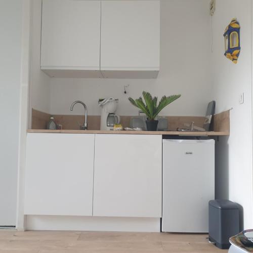 une cuisine avec des placards blancs et un comptoir dans l'établissement Studio Amèlie les bains, à Amélie-les-Bains-Palalda