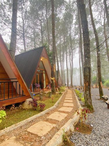 a cabin in the woods with a path leading to it at Great Panorama Lodge and Camping in Lembang