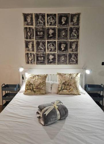 Una cama blanca con una bolsa encima. en Good Times Accomodation Cuneo en Cuneo