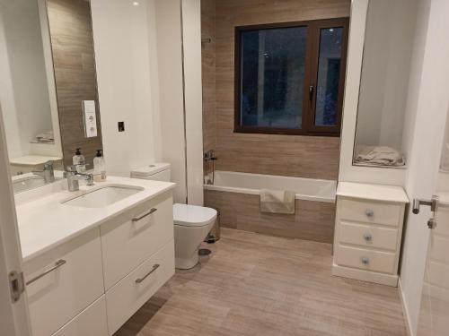La salle de bains est pourvue d'un lavabo, de toilettes et d'une baignoire. dans l'établissement Casa con vistas al mar en Pontevedra, à Pontevedra