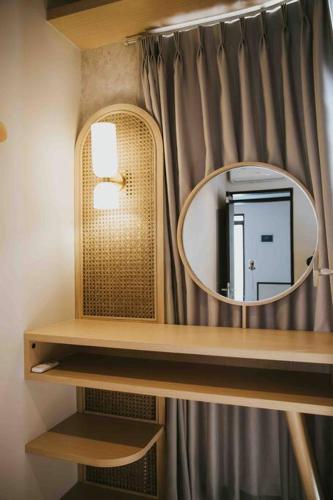 a mirror on a shelf in a bathroom with a curtain at Twelve Stones at Wahoo KBP in Padalarang