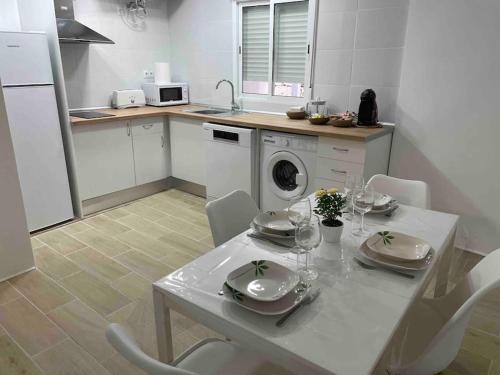 塔拉桑納阿拉貢的住宿－Acogedor Apartamento Casco Histórico de Tarazona，厨房配有白色的桌椅和洗衣机。