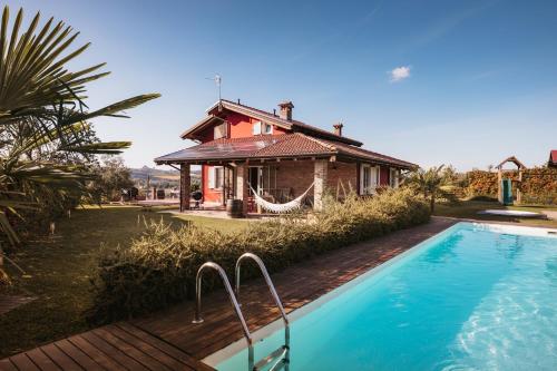 a house with a swimming pool in front of a house at Villa Gramolina Nizza in Nizza Monferrato