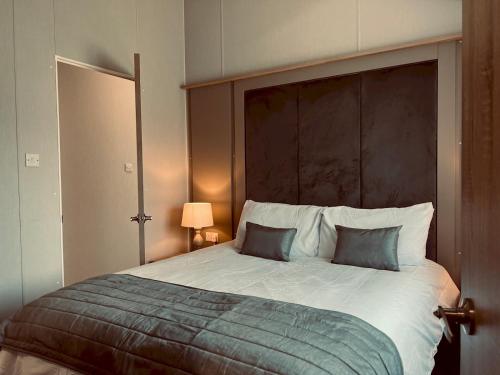 ein Schlafzimmer mit einem großen Bett mit zwei Kissen in der Unterkunft Pass the Keys Luxury Lakeside Lodge in New Romney