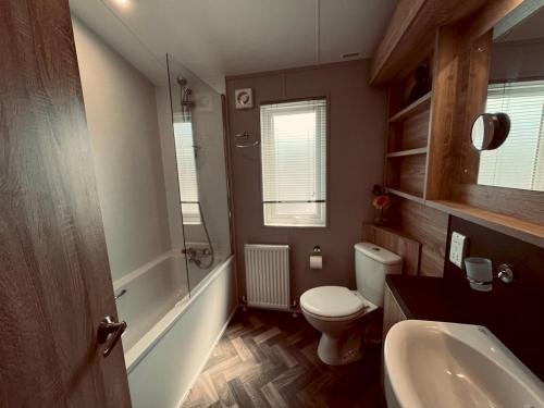 a bathroom with a white toilet and a sink at Pass the Keys Luxury Lakeside Lodge in New Romney