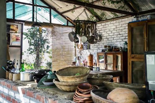 a kitchen with bowls and baskets on a brick wall at Petrichor - Regenerative Living Experience in Gorubathān