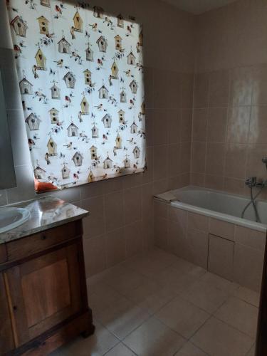 een badkamer met een bad en een douchegordijn met honden bij Maison de campagne in Ambleny