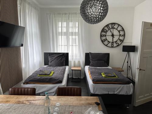 bee Design Apartment + Zentral + Küche + Parken في فيتسلار: غرفة بسريرين وساعة على الحائط