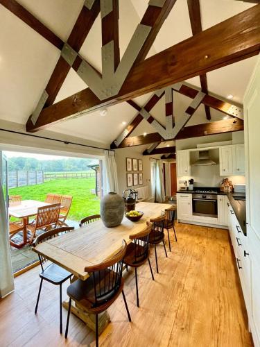 a kitchen and dining room with a table and chairs at Stone Barn in Farnham