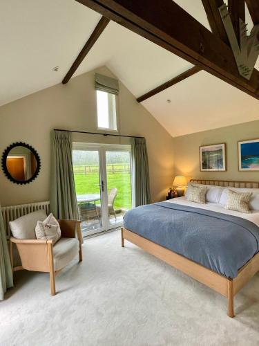 1 dormitorio con 1 cama grande y 1 silla en Stone Barn en Farnham