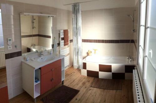 a bathroom with a tub and a sink and a bath tub at Gîte de vacances avec jardin arboré in Nieul-le-Dolent