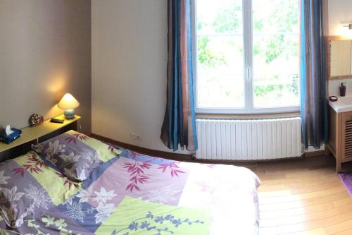 a bedroom with a bed and a large window at Gîte de vacances avec jardin arboré in Nieul-le-Dolent