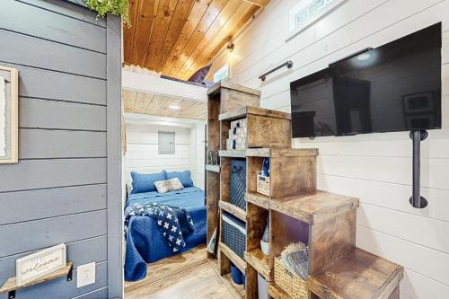 Cozy Lakeview Cottage في Mills River: غرفة نوم في منزل صغير مع تلفزيون وسرير