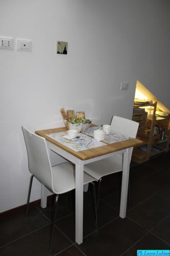a dining room table with two white chairs at Happyhouse in Turin
