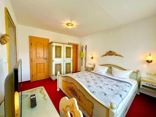 a bedroom with a large bed and a desk at Hotel Bergland in Grainau