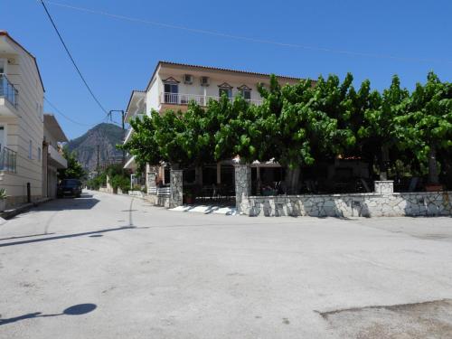 a street with a tree in front of a building at Panorama Hotel - Restaurant in Diakopto