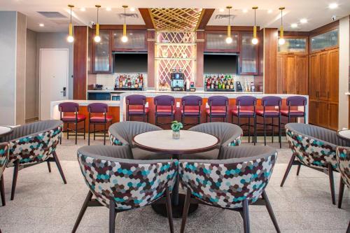 a bar in a restaurant with chairs and a counter at Hyatt Place St Augustine Vilano Beach in Saint Augustine