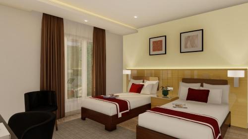 um quarto de hotel com duas camas e uma cadeira em M Central em Chennai