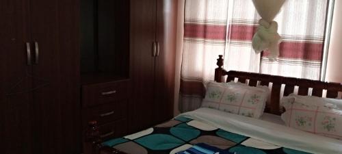 ein kleines Schlafzimmer mit einem Bett und einem Fenster in der Unterkunft Kaks apartments in Kampala