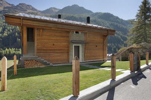 a log cabin with a fence in front of it at Valgrisa Mountain Lodges 1 in Valgrisenche