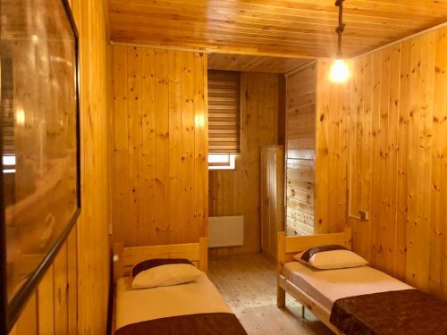 a room with two beds in a wooden cabin at WOOD MOTEL in Mingachevir