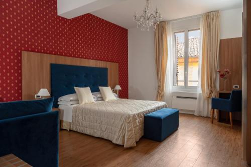 een slaapkamer met een bed en een blauwe stoel bij Albergo Rossini 1936 in Bologna