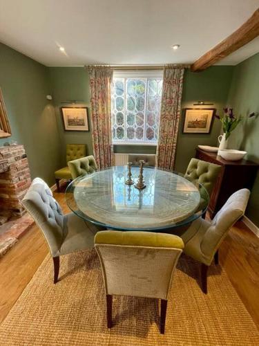 a dining room with a glass table and chairs at Northbrook Cottage, Farnham, up to 8 adults in Farnham