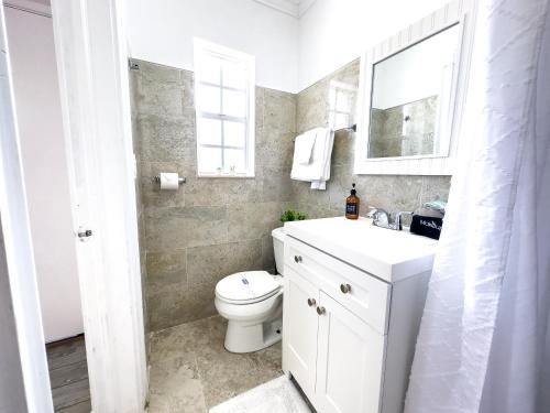 a white bathroom with a toilet and a sink at King Suite Apt With Shared Pool 02 in Clearwater