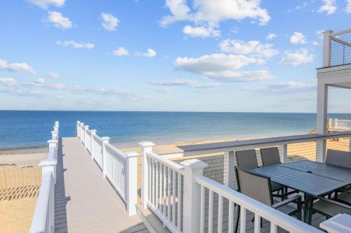 a balcony with a table and a view of the beach at 114 Salt Marsh Road East Sandwich Seaglass in East Sandwich