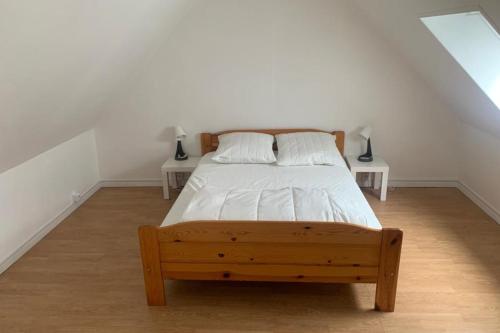 - une chambre avec un lit en bois et 2 tables dans l'établissement Pretty Norman pearl with garden, à Hermanville-sur-Mer