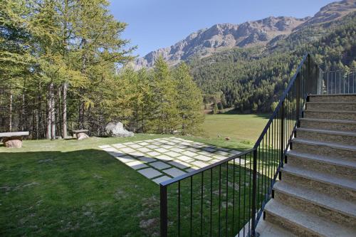 a set of stairs leading to a lawn with mountains at Valgrisa Mountain Lodges 3 in Valgrisenche