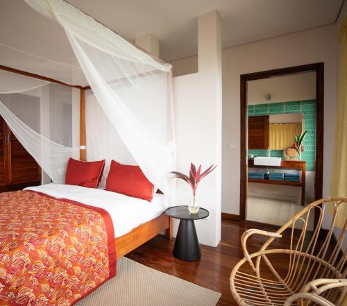 a bedroom with a bed with red pillows at Villa Principe in Santo António