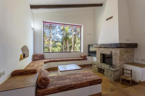 ein Wohnzimmer mit einem Kamin und einem großen Fenster in der Unterkunft Villa Stella Nord in Marsala