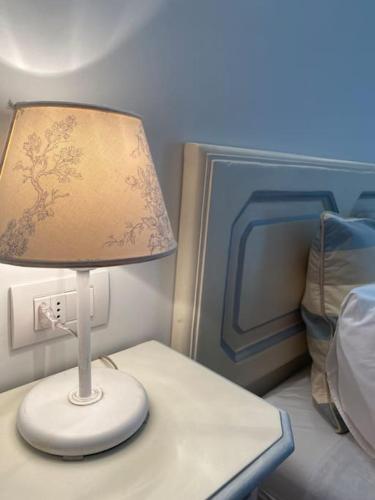 a lamp sitting on a table next to a bed at La casa di Giò: piccolo gioiello in centro Como in Como
