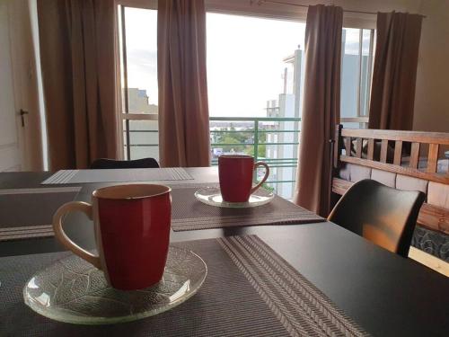 two coffee cups sitting on a table with a balcony at Loft6 a solo 2 cuadras de la Costanera!!! in Corrientes