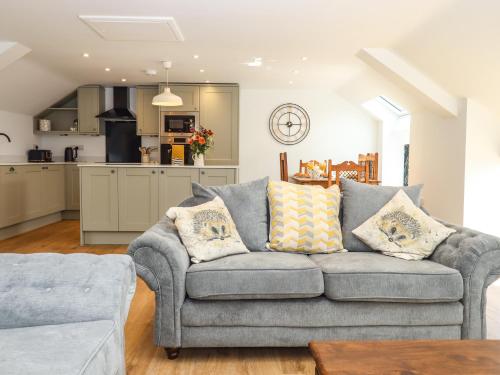 a living room with a couch and a kitchen at Bumblebee Cottage in Wellington