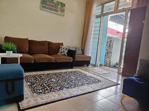 sala de estar con sofá y alfombra en MunadibStay Private Pool, en Ketereh