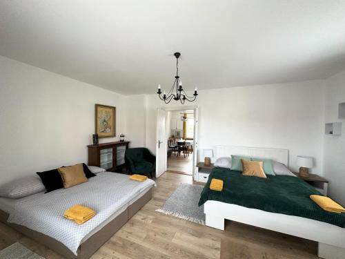 1 dormitorio con 2 camas y lámpara de araña en Apartments Old Town, en Brandýs nad Labem-Stará Boleslav