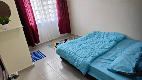- une chambre avec un lit et une couette bleue dans l'établissement MunadibStay Private Pool, à Ketereh