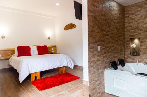 a bedroom with a bed and a bathroom with a tub at Hospedaje Vista Hermosa Salento in Salento