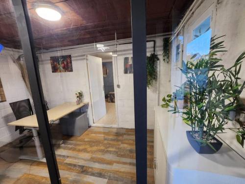 ein Büro mit einem Schreibtisch und Pflanzen in einem Zimmer in der Unterkunft Maison proche Paris JO 2024 in Franconville