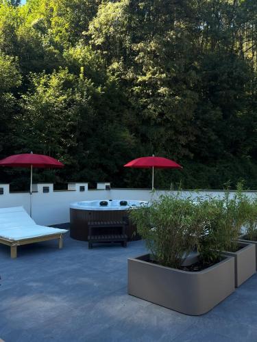 a patio with two umbrellas and a table and benches at Landgasthof zur Burg Grenzau in Höhr-Grenzhausen