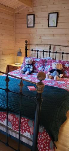 a bedroom with a bed with teddy bears on it at Hot Tub Unique Farm Stay in Pallis Bridge