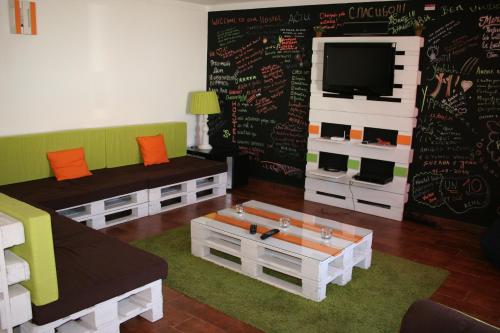 a living room with a chalkboard wall with a tv at Santa Maria do Mar Guest House in Peniche