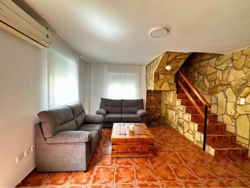 a living room with two couches and a stone wall at Chalet en La Mata a 50 metros de la playa in Torrevieja
